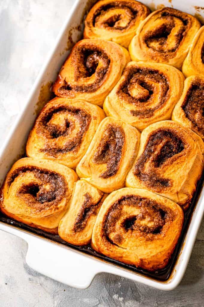 White baking dish with baked caramel rolls in it