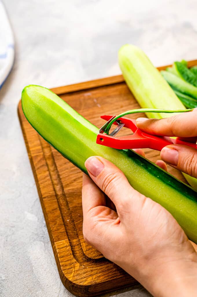 Hands peelings a cucumber