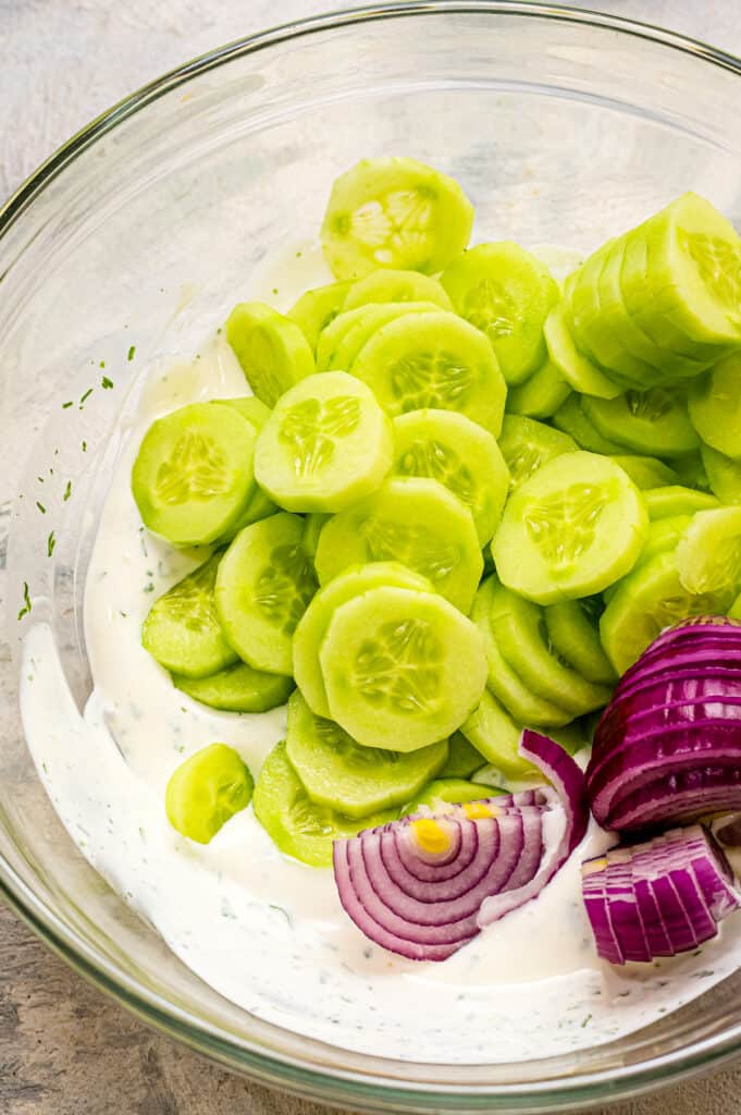 Glass bowl with cucumber salad ingredients before mixing