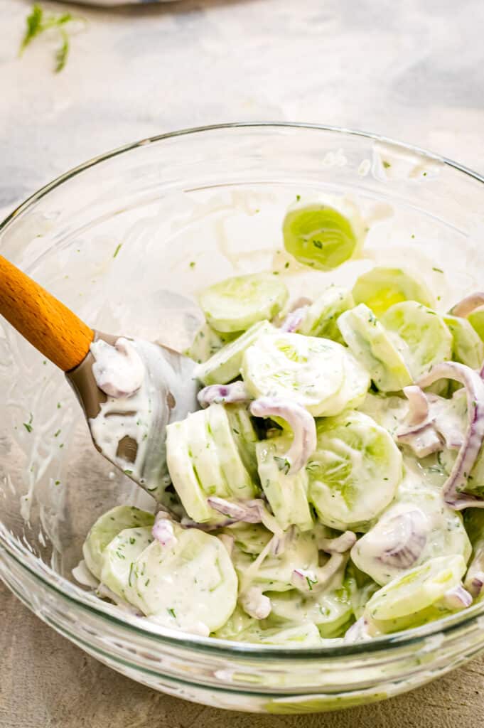 Glass bowl with cucumber salad ingredients after mixing
