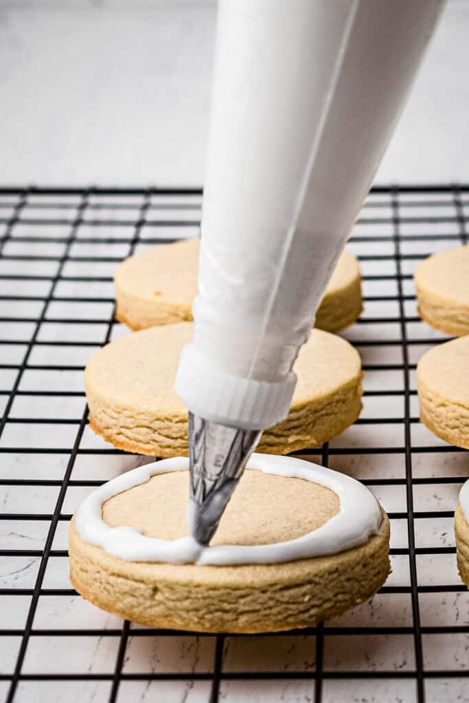 Piping royal icing on sugar cookie