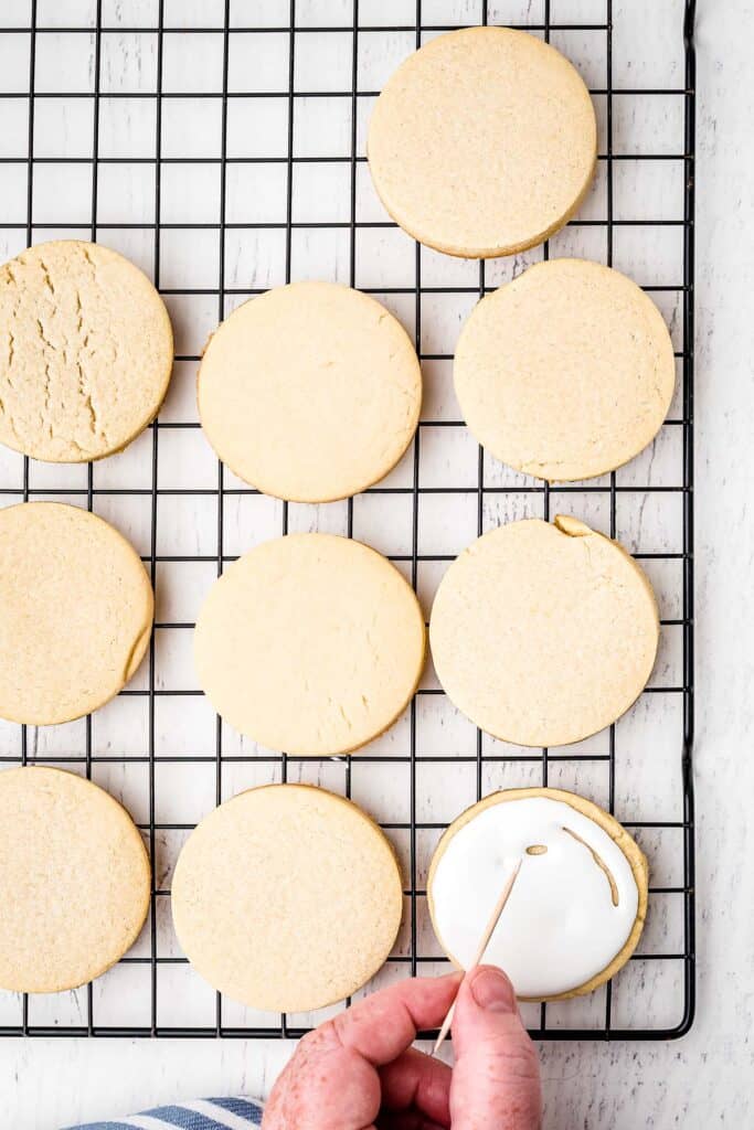 Sugar Cookie spreading royal icing out with toothpick