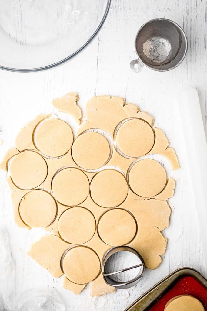 Round cookie cutter cutting out of sugar cookie dough