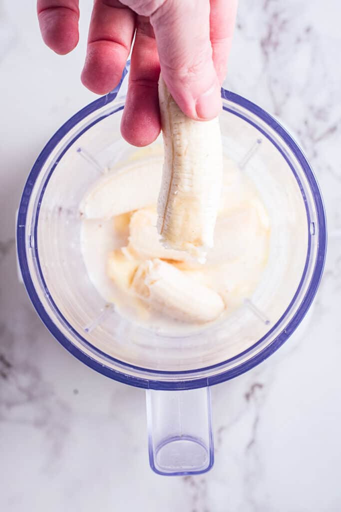 Putting a banana in blender to make a milkshake