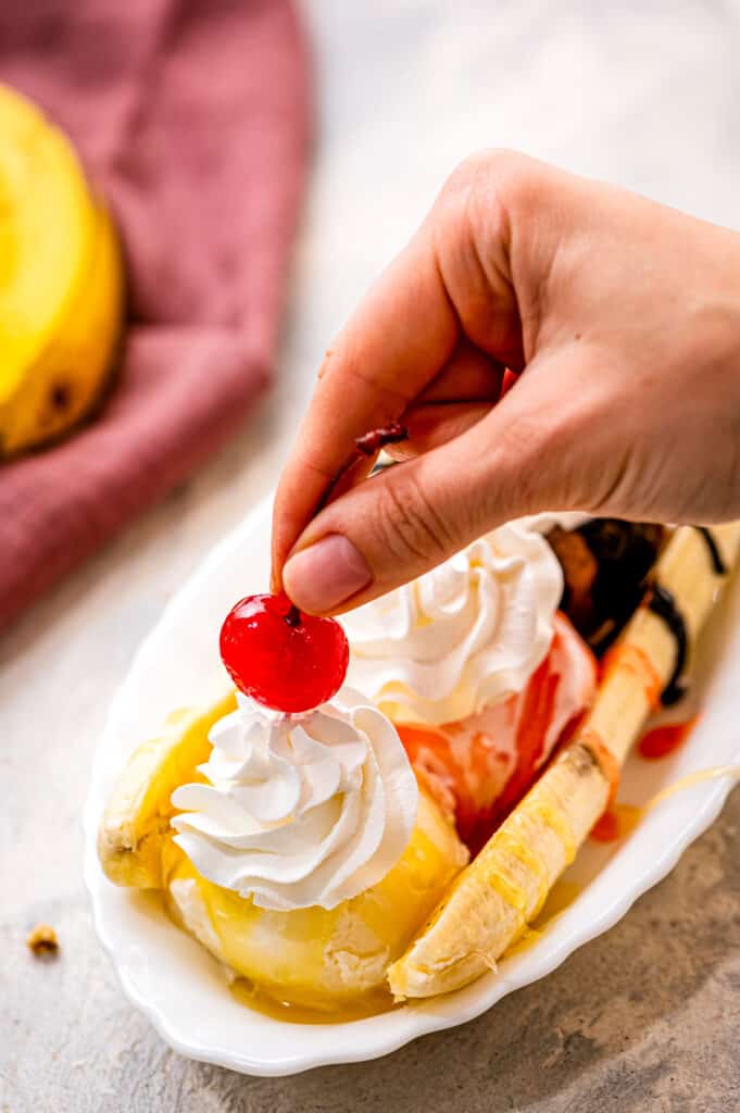 Placing a maraschino cherry on top of whipped cream