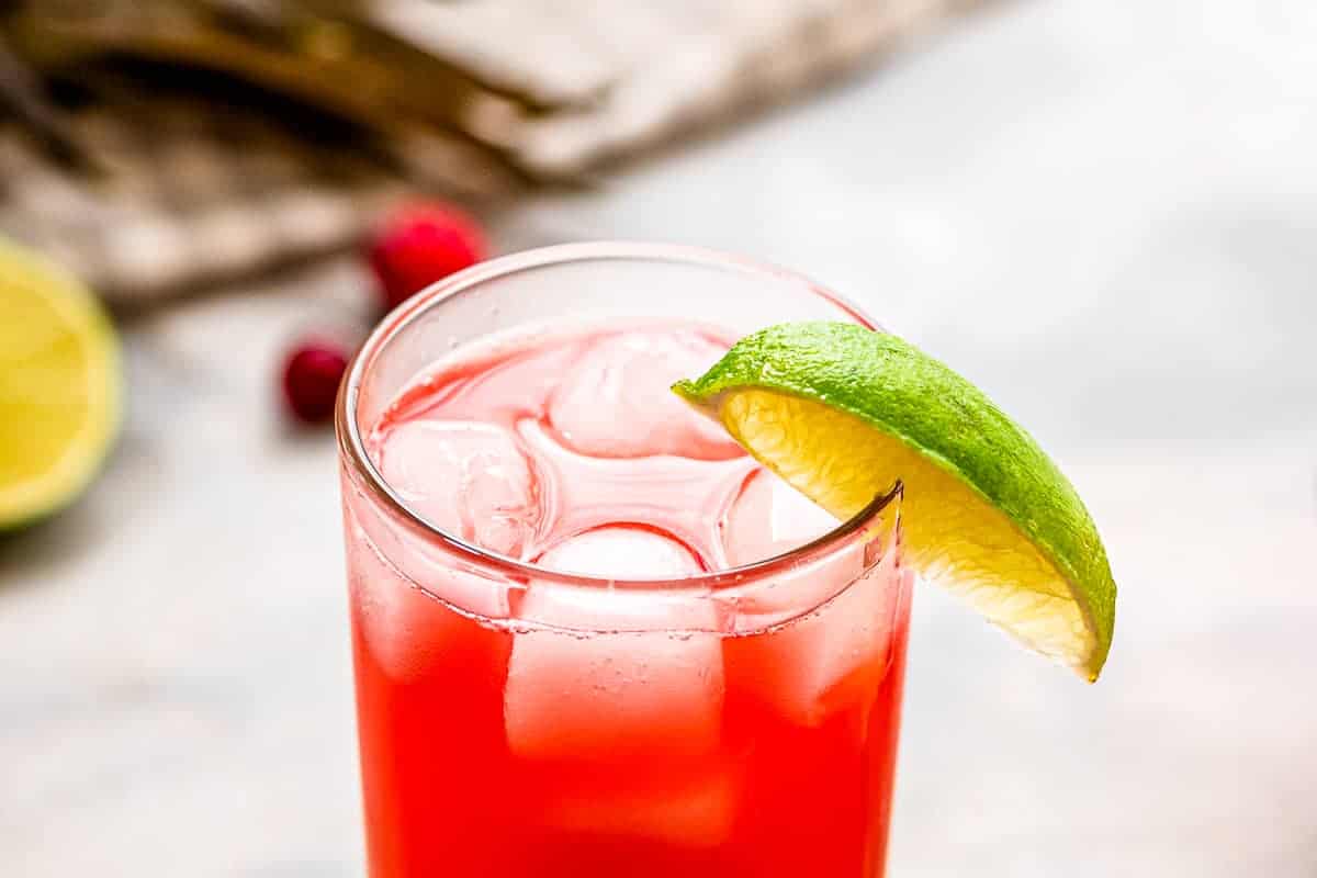 Cocktail in tall glass with lime wedge as garnish