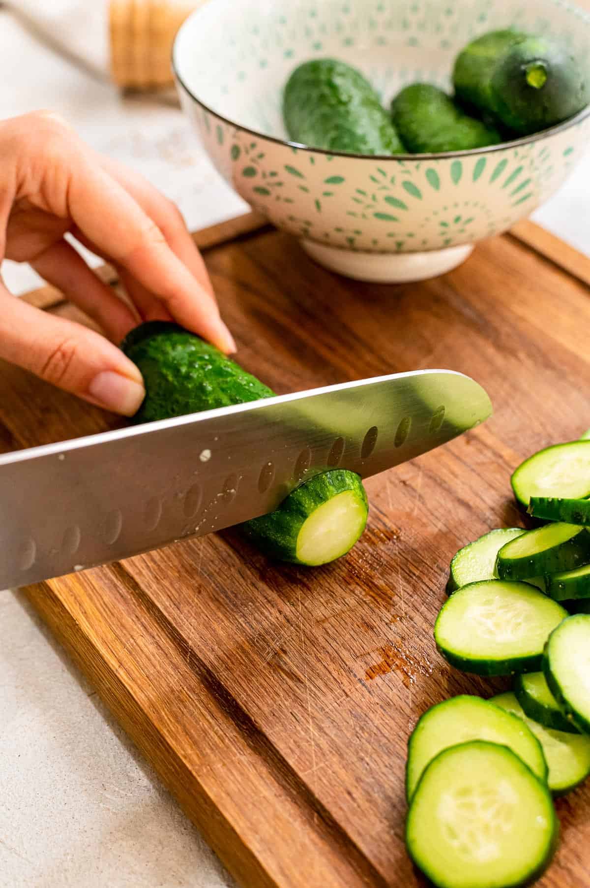 Chef knife slicing cucumbers