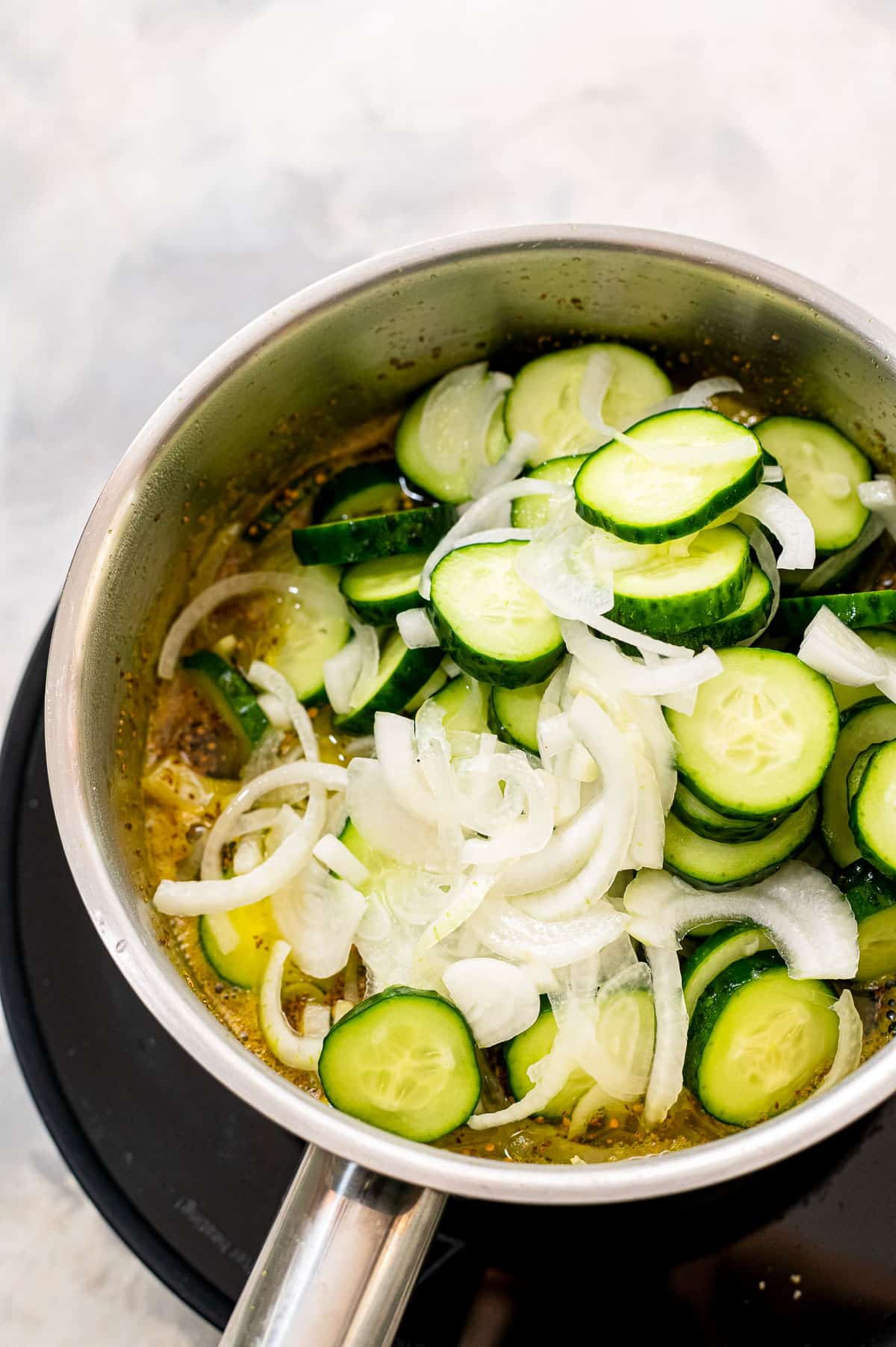 Saucepan with cucumbers, onions and vinegar mixture