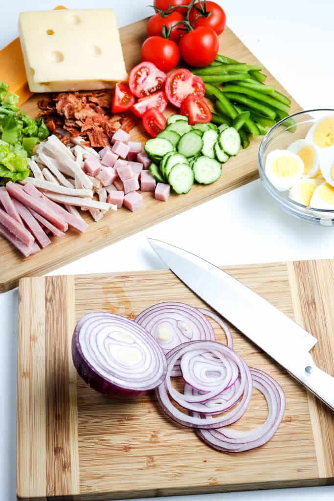 Cutting board with knife and red onion