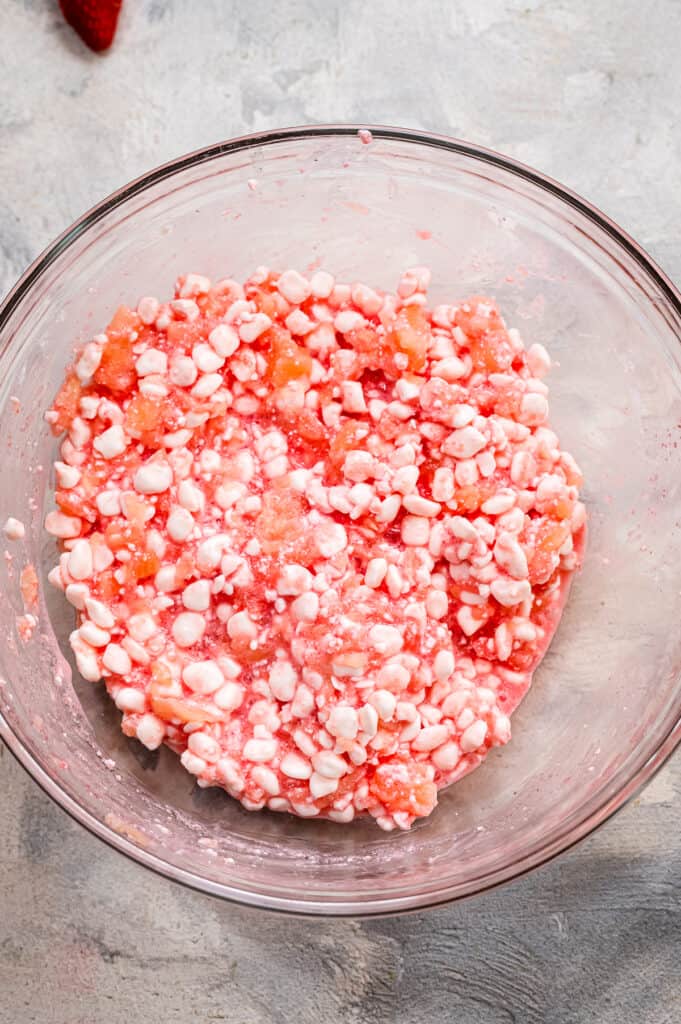 Glass bowl with strawberry jello powder and cottage cheese mixed together