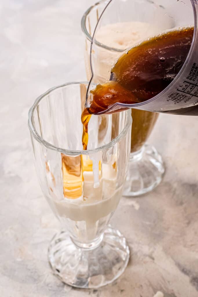 Pouring root beer into glasses with vanilla ice cream