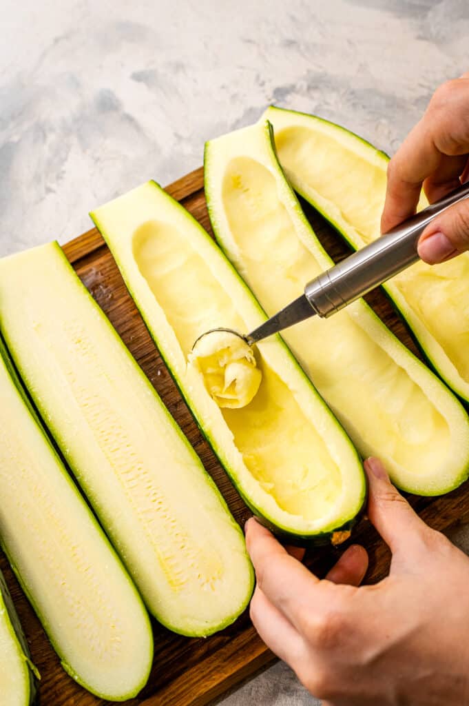 Melon baller scooping inside of zucchini out