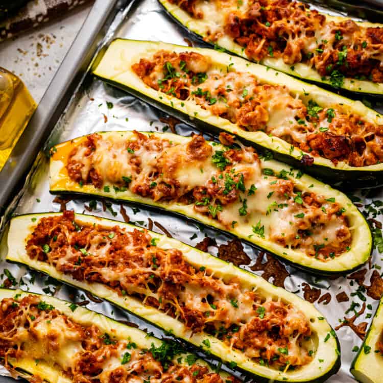 Overhead image of stuffed zucchini boats on foil lined baking sheet