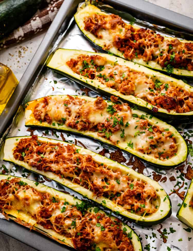 Overhead image of stuffed zucchini boats on foil lined baking sheet