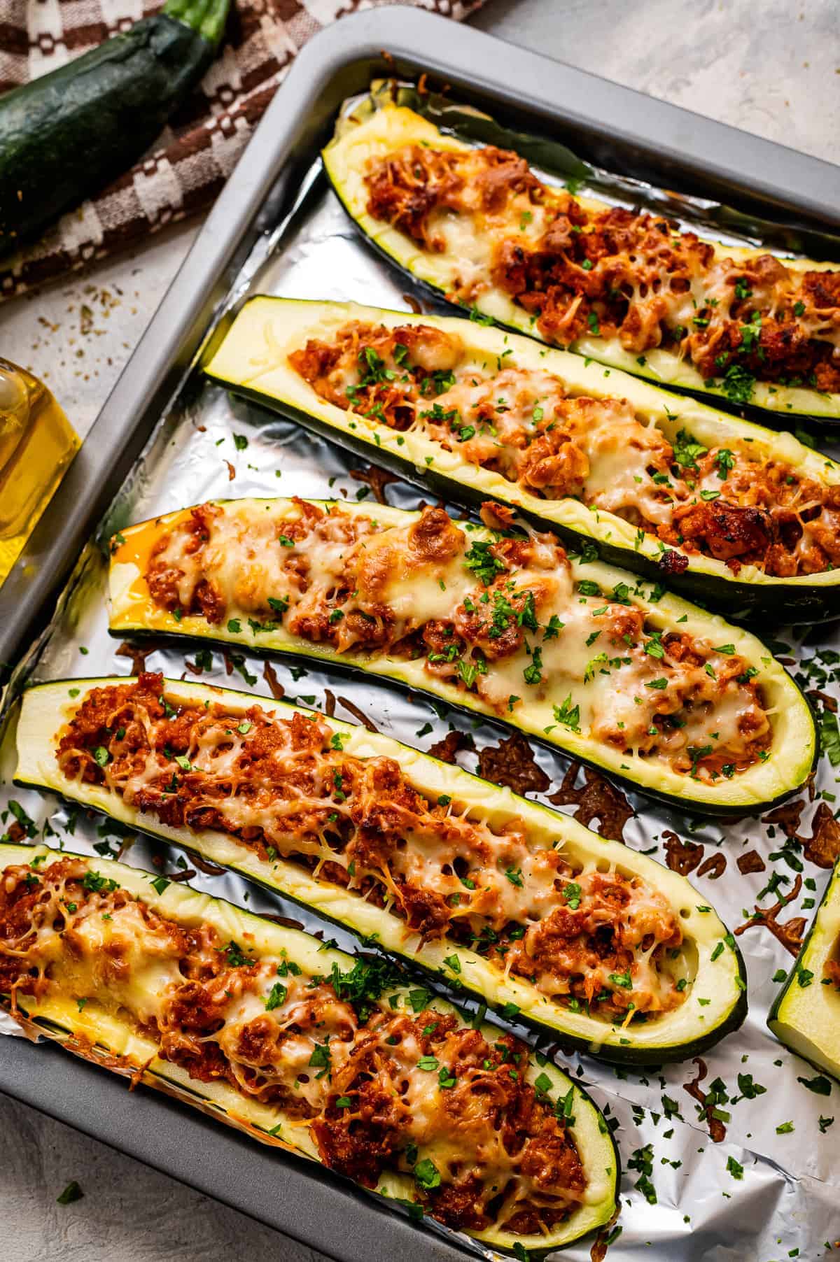 Overhead image of stuffed zucchini boats on foil lined baking sheet