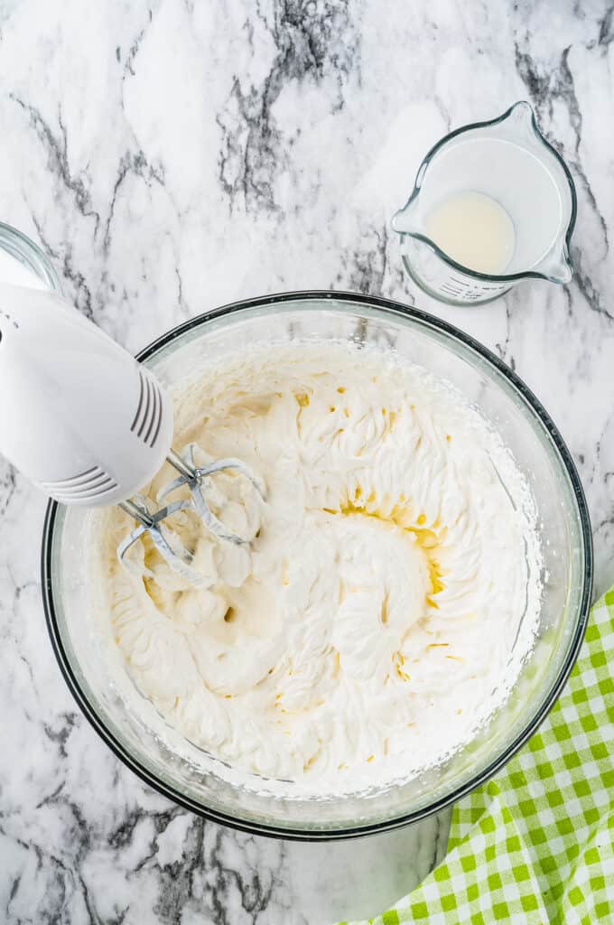 Hand mixer whipping cream to stiff peaks
