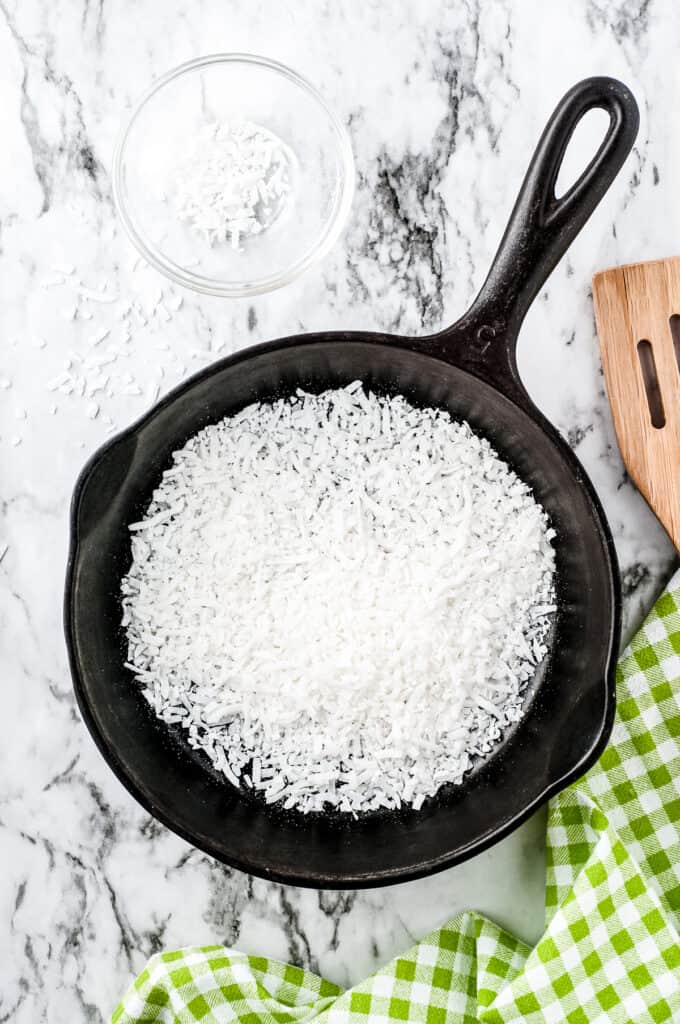 Cast iron skillet with coconut and wooden spatula