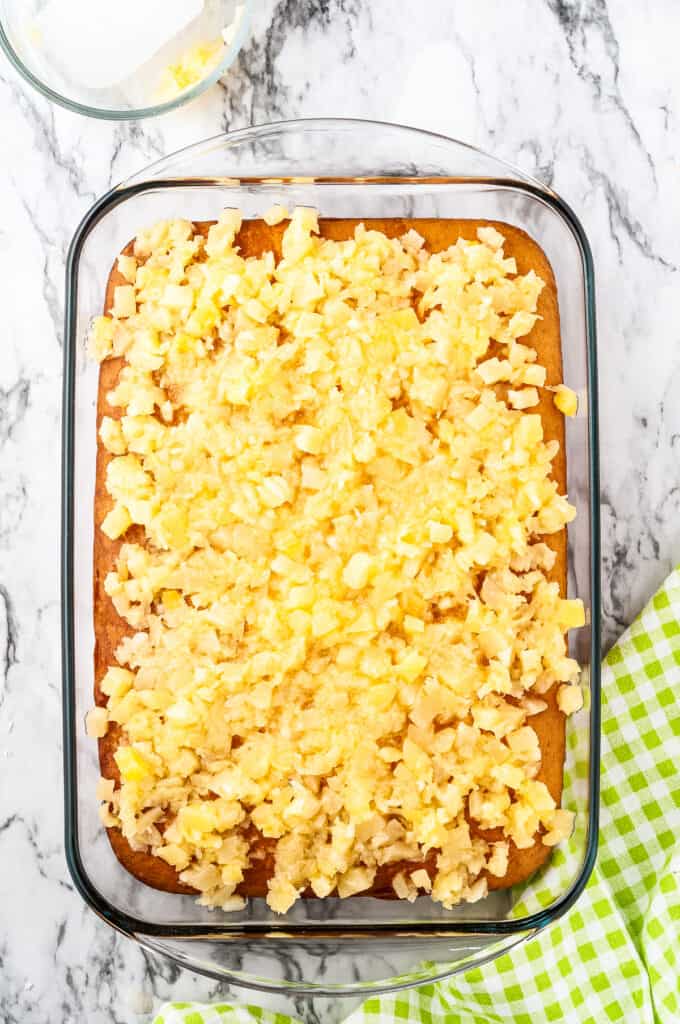 Overhead image of baked cake with crushed pineapple on top