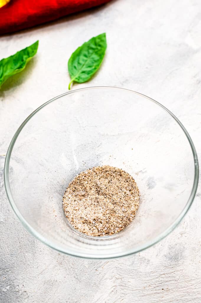 Glass bowl with garlic powder, salt and pepper mixed up