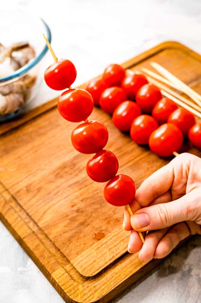 Hand holding a cherry skewer