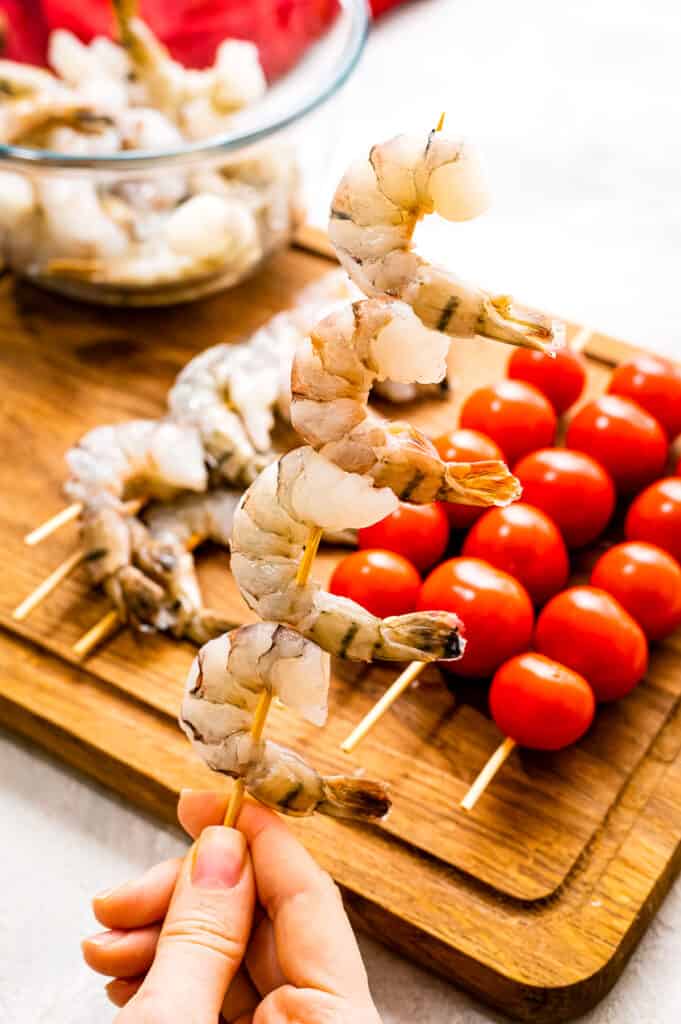 Hand holding a shrimp skewer