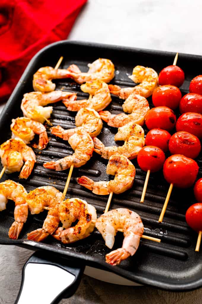 Grill pan with skewers of shrimp and cherry tomatoes