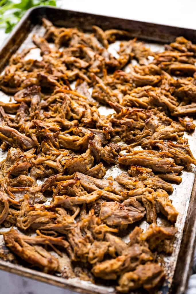 Sheet pan with pulled pork shoulder after broiling