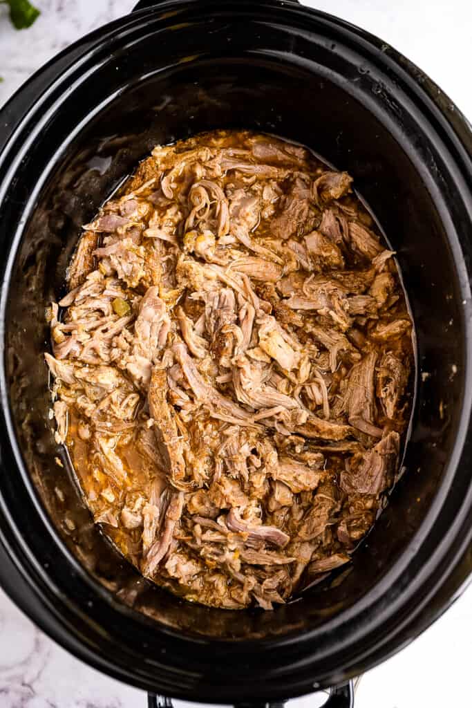 Shredded pork in crock pot with juices