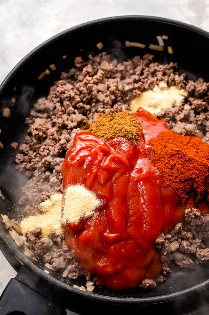 Skillet with ground beef, tomato sauce and seasonings