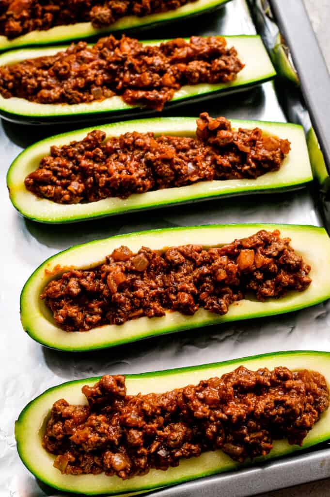 Zucchini with taco meat mixture in them before baking