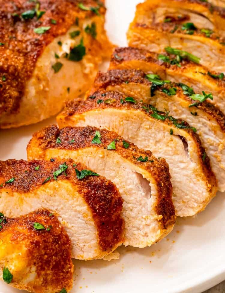 Sliced chicken breasts with seasoning on it