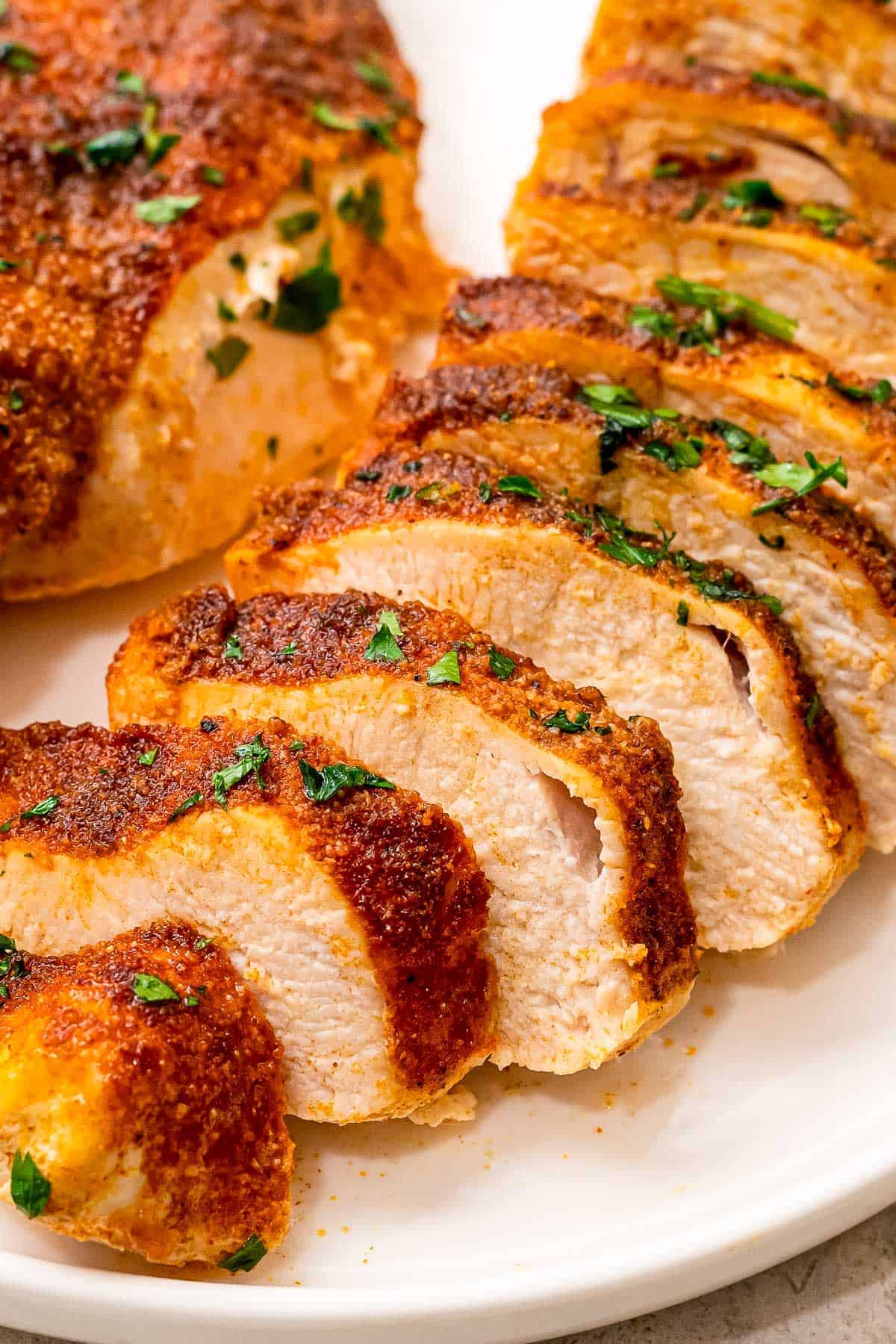 Sliced chicken breasts with seasoning on it