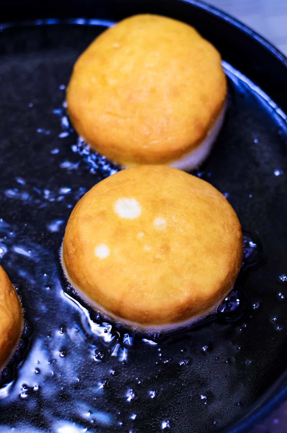 Skillet with oil frying donuts