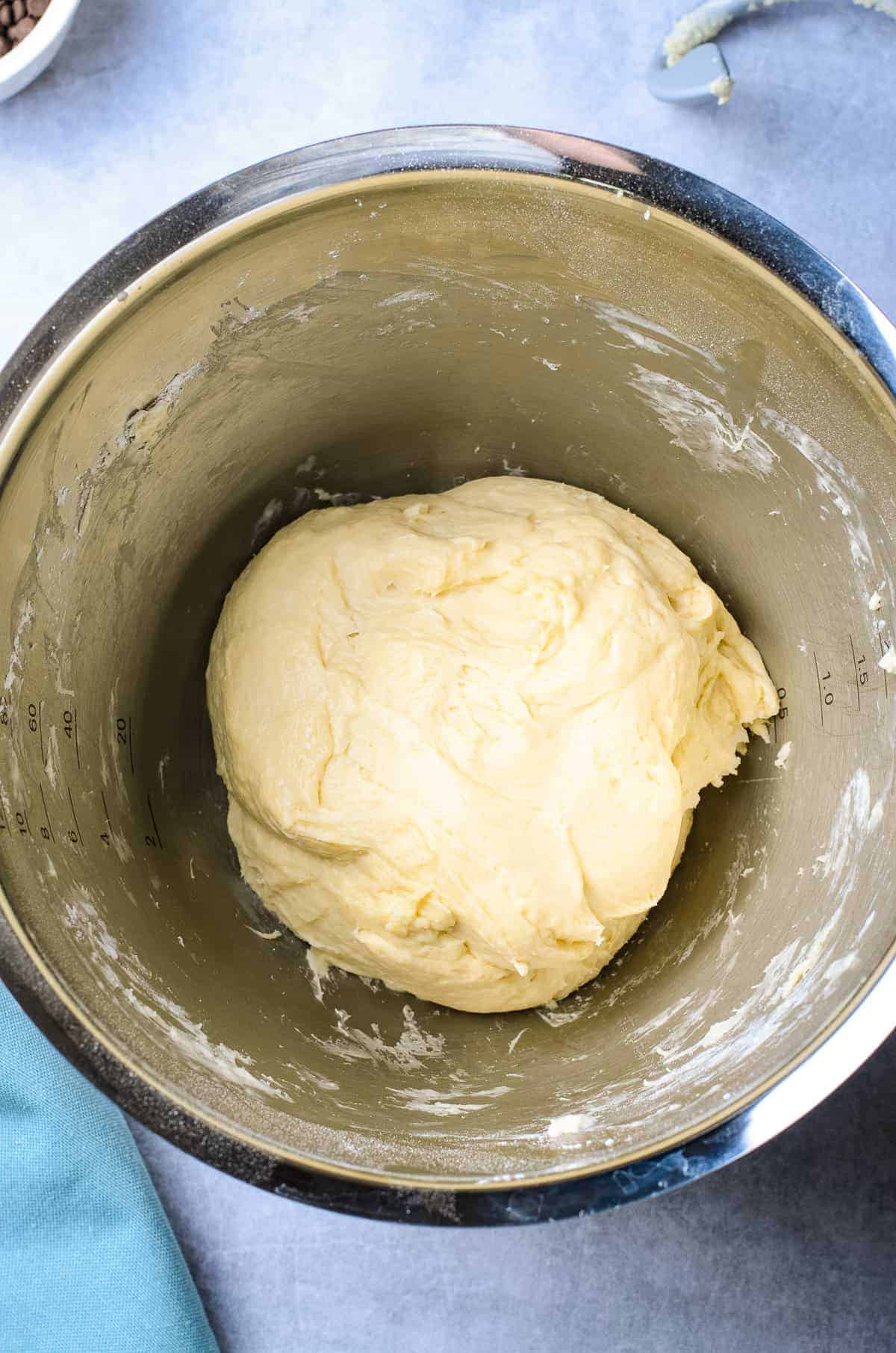 Donut dough in stainless steel bowl before rising