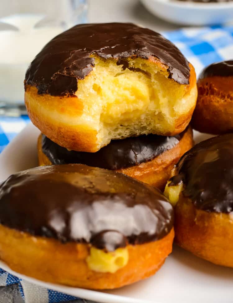 Stack of Boston Cream Donuts with a bite out of the middle