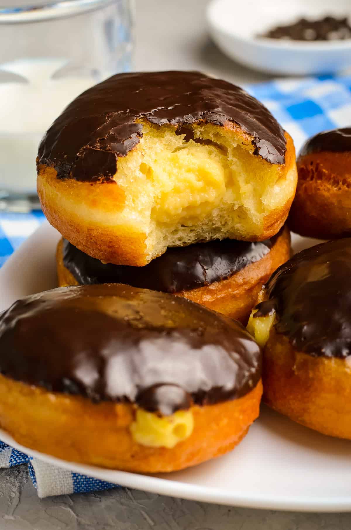 Stack of Boston Cream Donuts with a bite out of the middle