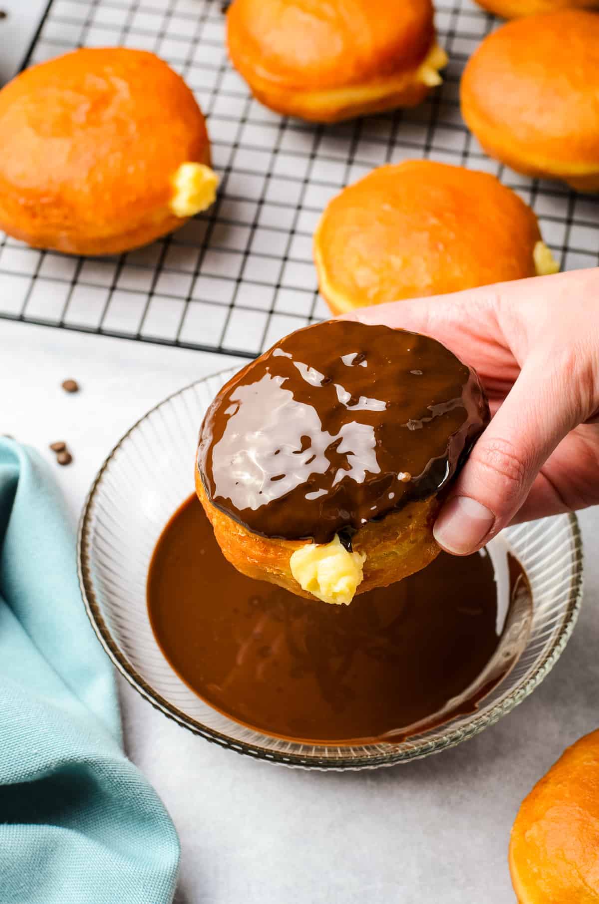 Hand holding Boston Cream Donut