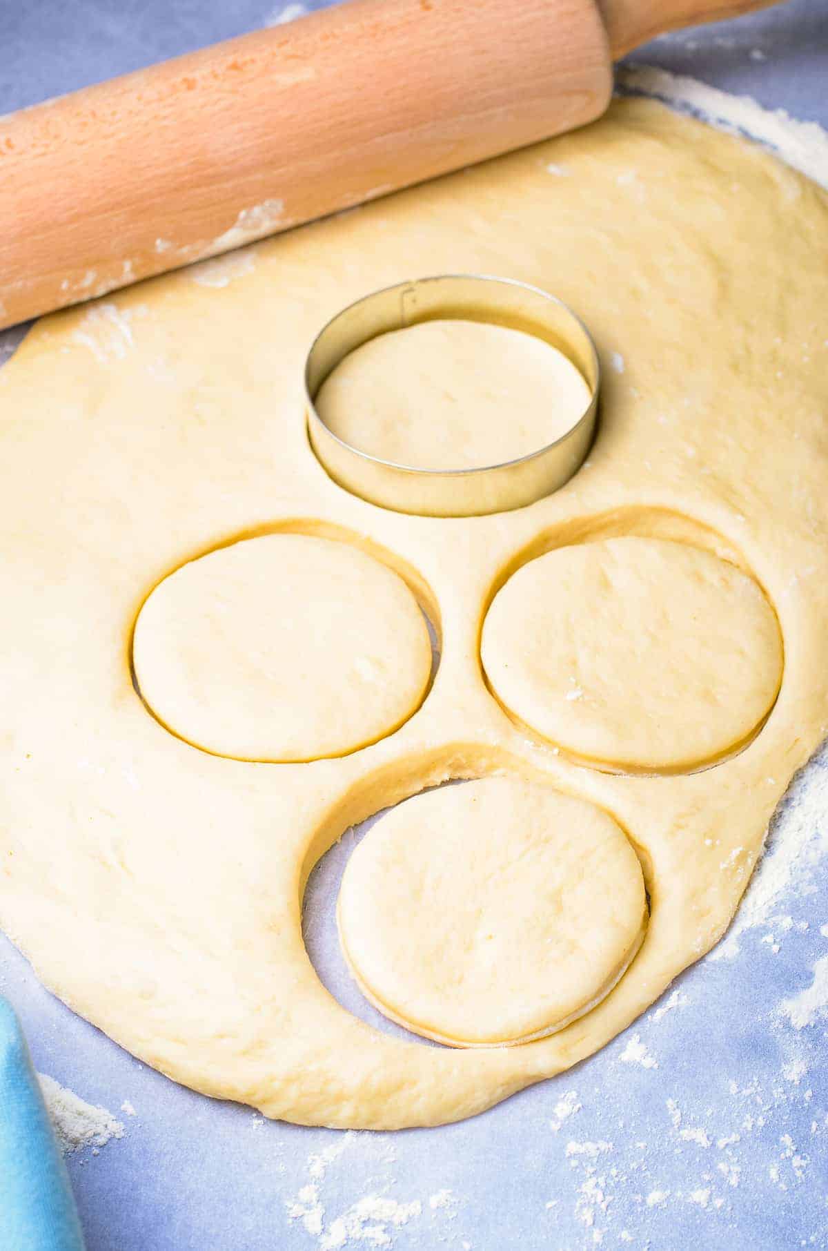 Biscuit cutter cutting rolled out donut dough