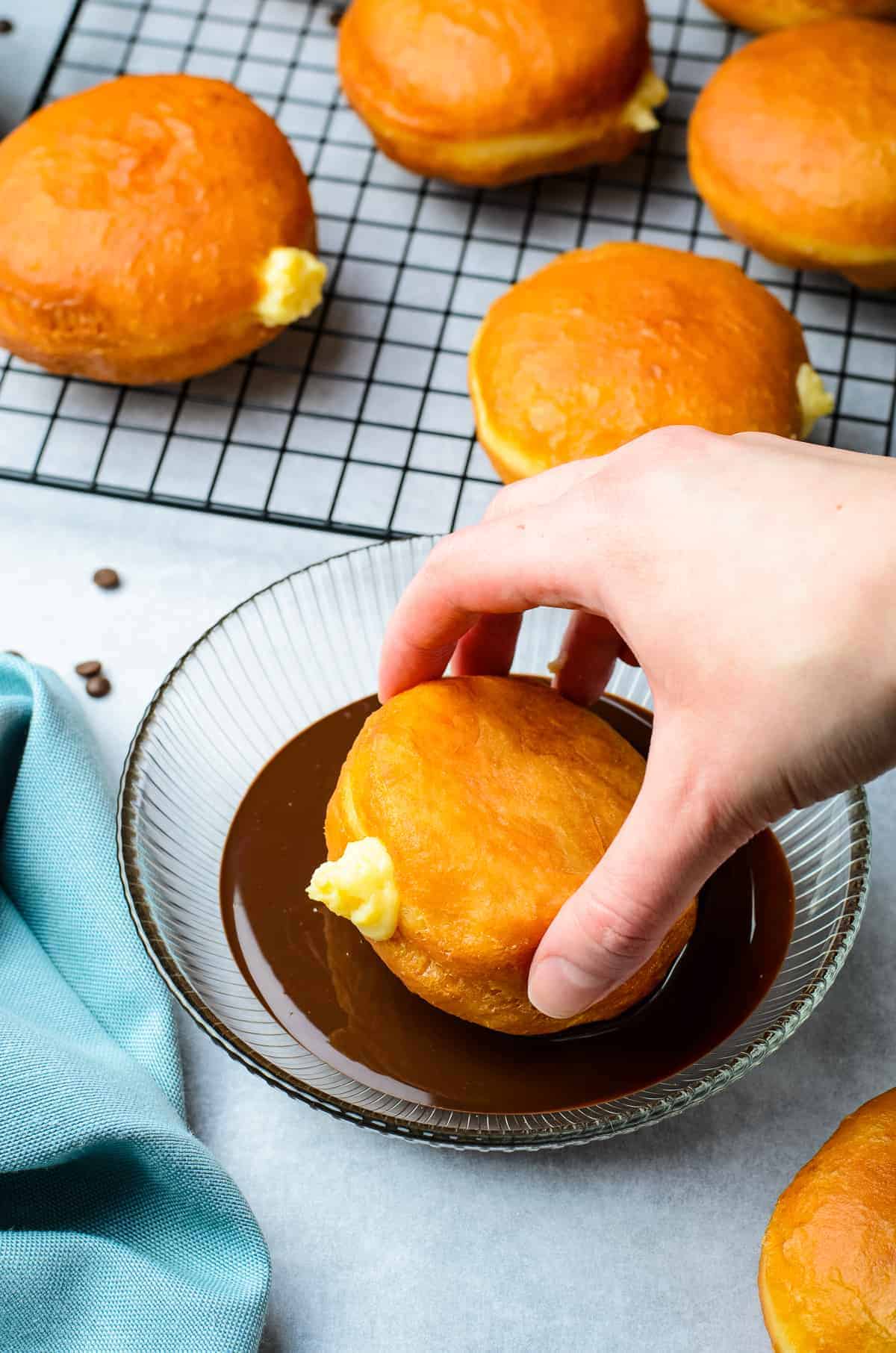 Dipping Boston Cream Donut in chocolate glaze