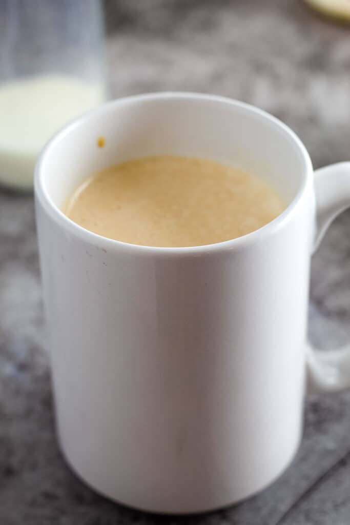 White coffee mug with sweetened coffee in it