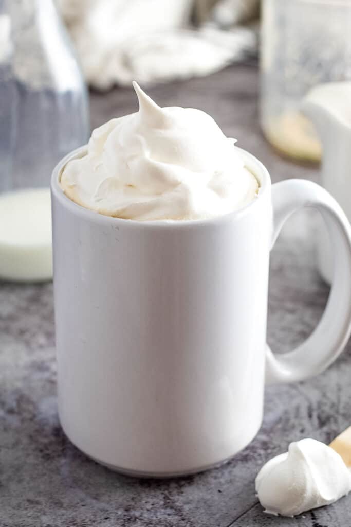 White coffee mug with whipped cream on top