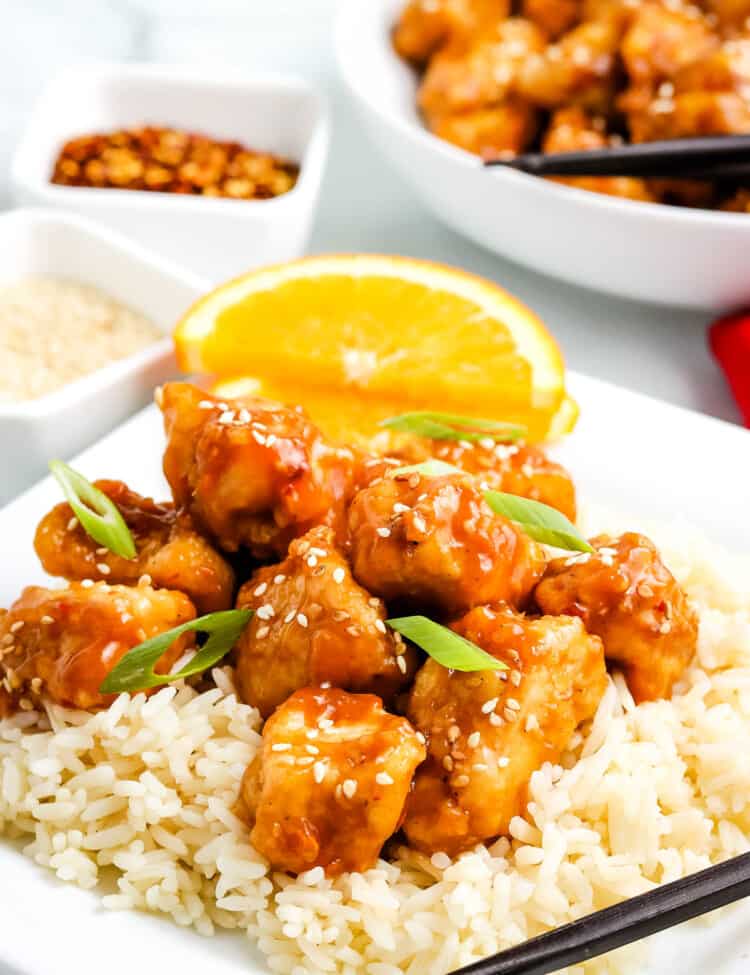 Orange chicken on top of rice on plate