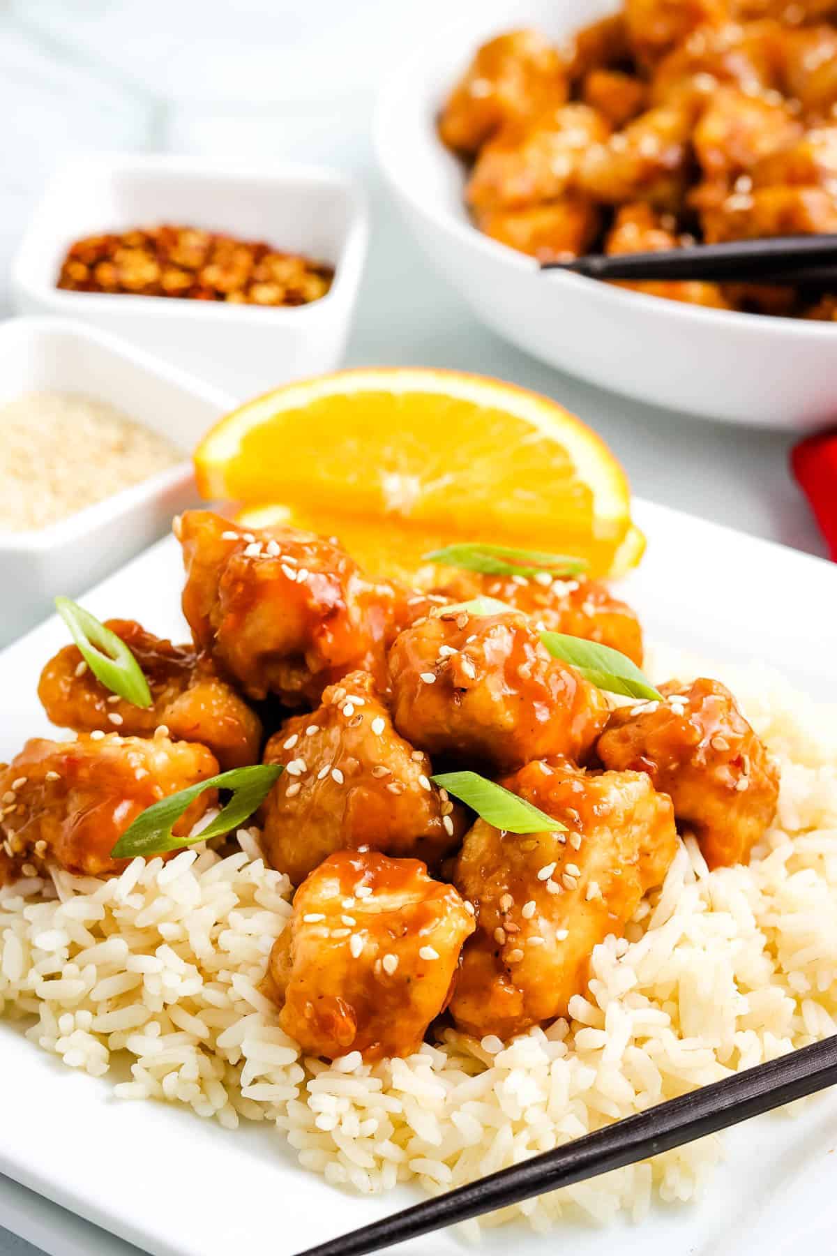 Orange chicken on top of rice on plate