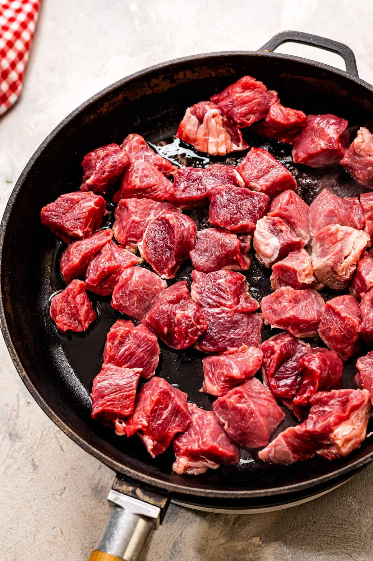 Pieces of steak in cast iron pan