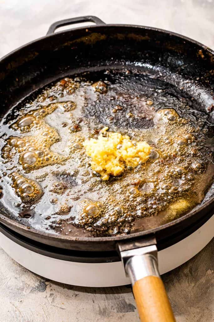 Cast iron pan sautéing garlic in butter