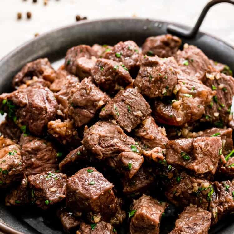 Steak Bites with Garlic Butter on black serving platter
