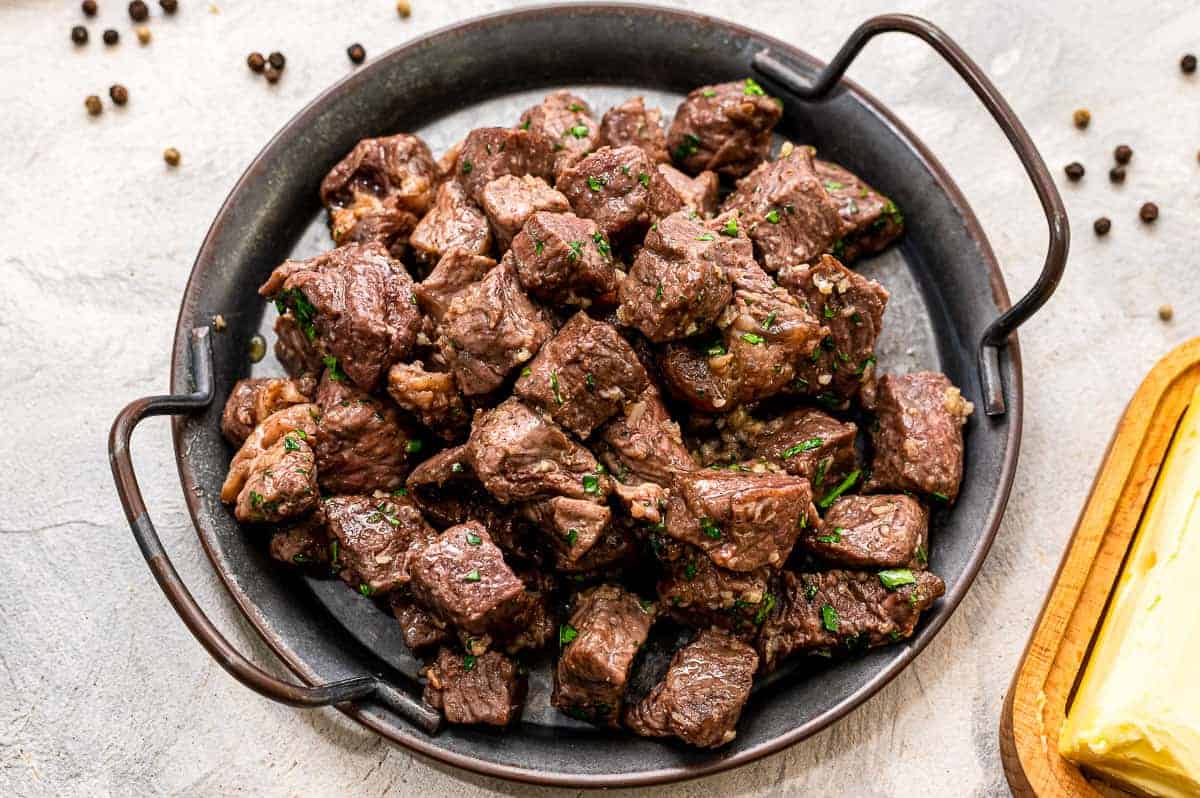 Air Fryer steak bites with garlic butter on black serving tray