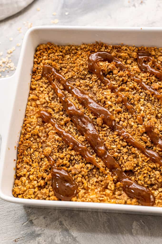 Pan of Apple Cheesecake Bars topped with caramel
