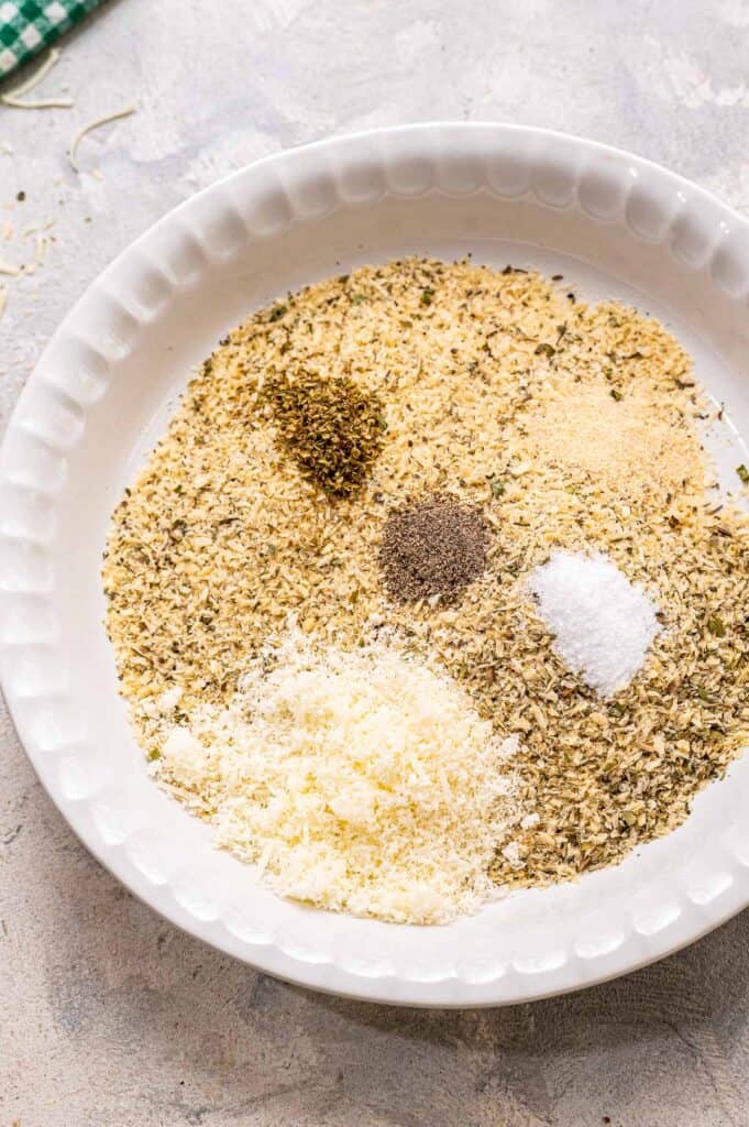 White pie plate with breadcrumbs and seasonings