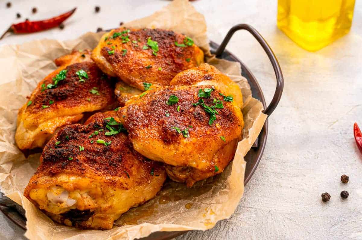 Serving tray with baked chicken thighs on it